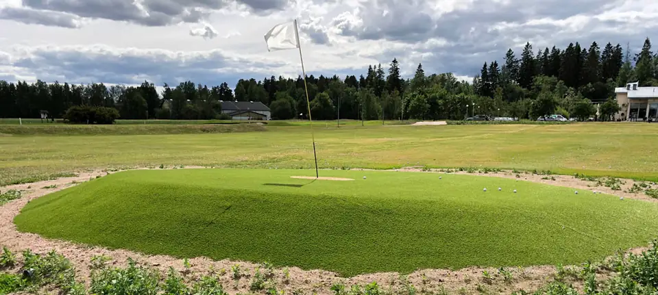 Pyöreä kohdeviheriö rangella, taustalla metsää.