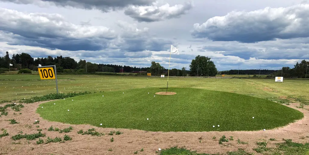 Hiekkaharju Golfin rangen pyöreä kohdeviheriö ja 100 metrin kyltti.