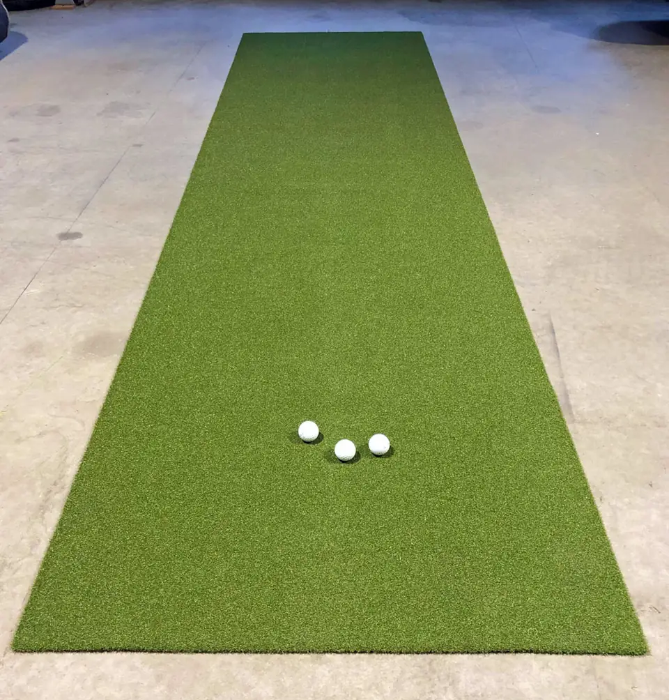 100 cm leveä puttimatto betonilattialla, matolla kolme golfpalloa.